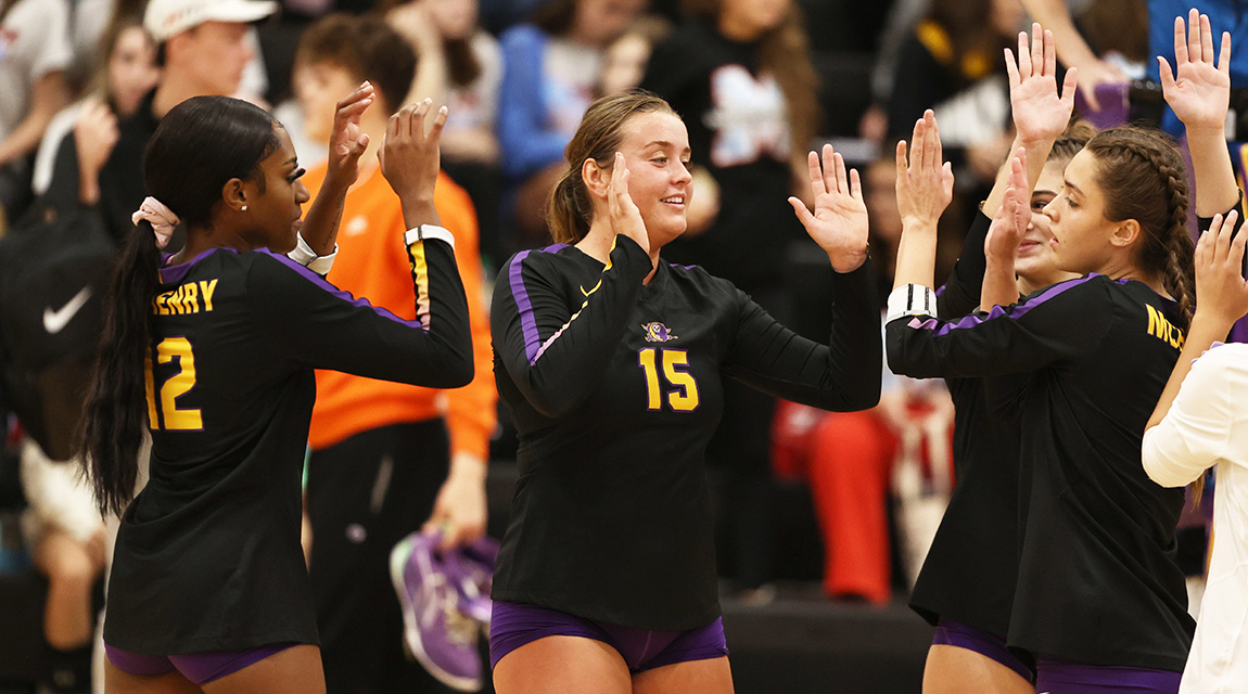 Scots volleyball players give each other triumphant high fives on the court. 
